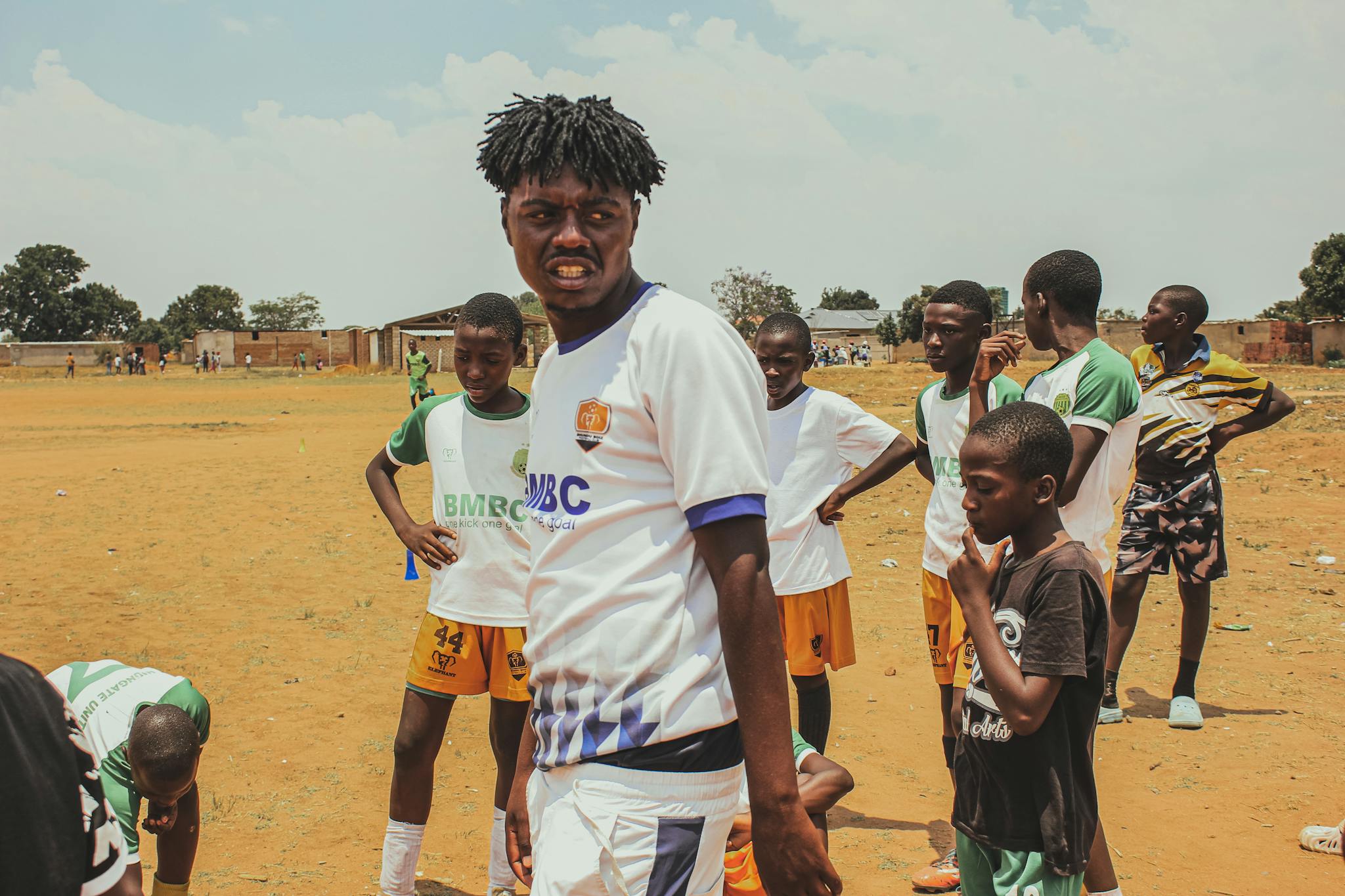 Youth soccer players gathered on a sunny day at an outdoor field, showcasing teamwork and camaraderie.